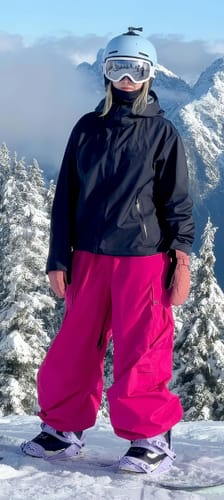 Customer stands on a snowy mountain wearing the dark waterproof insulated snow jacket.