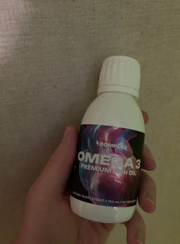 Customer holding a white bottle of Complex Omega 3 Premium Fish Oil in their hand.