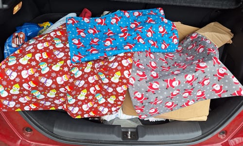 Customer's festive Happy Snowman Polycotton Fabric and other Christmas materials piled in the back of a car.
