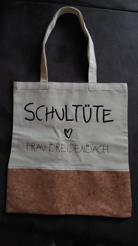 Personalisierte Einkaufstasche eines Kunden aus Baumwolle und Kork mit dem Aufdruck 'Schultüte ♡ Frau Breidenbach'.