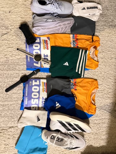 Customer's white adidas Adizero EVO SL Running Shoes laid out flat with running apparel for two people.