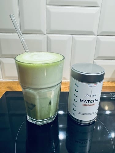 Photo d'un client : un matcha latte glacé dans un verre, à côté de la boîte de THÉ MATCHA CÉRÉMONIE BIO.