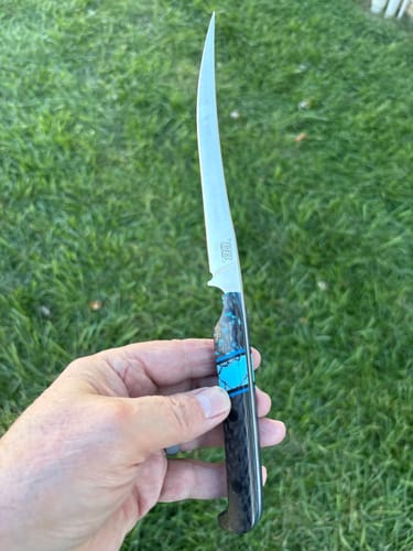 Customer holding a finished custom knife with a polished blade, made using the metal sanding belts.