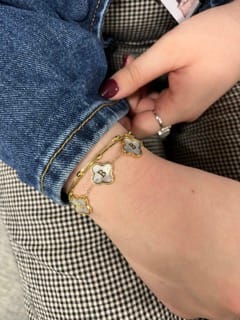 Customer wearing their personalized Custom Name Clover Bracelet with mother of pearl charms on their wrist.