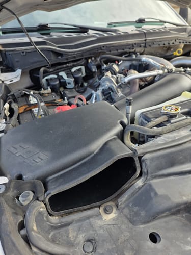 Reviewer's SPE Motorsport Air Intake System installed in an engine bay, showing a scrape on the corner from a tight fit.