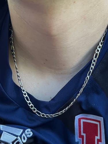 Primer plano de un cliente que lleva la Cadena Fígaro de 5 mm en el cuello.