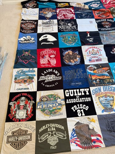 Customer's large Premium T Shirt Quilt, made from colorful Harley-Davidson shirts, laid out fully on a floor.