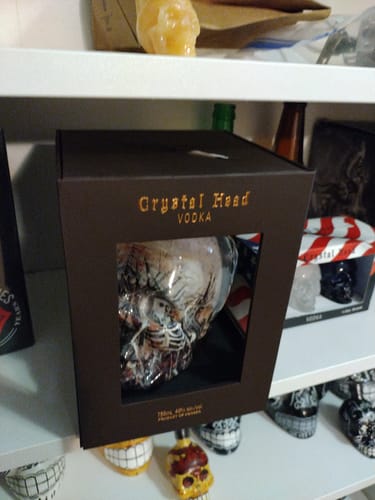 Customer's limited edition Crystal Head "John Alexander" Vodka inside its dark brown presentation box on a shelf.