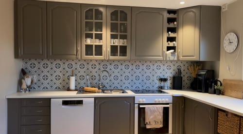 Anmelderens kjøkken med Clara grønn selvklebende fliser installert som en mønstret backsplash over benken.