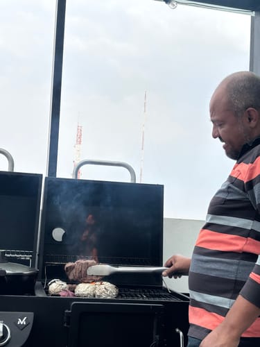 Cliente asando un corte del Kit Cortes Finos en una parrilla negra al aire libre.