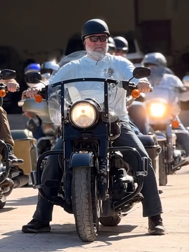 Reviewer wearing the low-profile, flat black SOA Beanie helmet while sitting on a motorcycle.