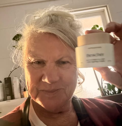 Reviewer holding up a jar of Sea Cucumber Collagen Anti-Ageing Cream for a selfie.
