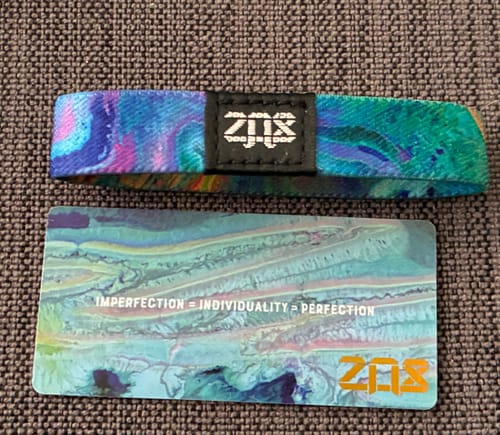 Customer's colorful Perfectly Imperfect Bracelet shown with its matching card reading 'Imperfection = Individuality = Perfection'.