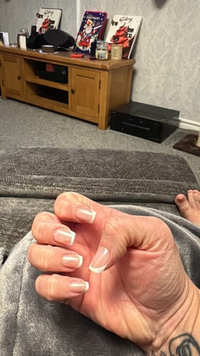 Close-up of a customer's hand wearing the French Glaze press-on nails, showing the short, square design.