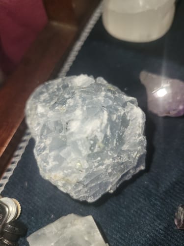 A reviewer's close-up of a raw light blue crystal from their VIP Crystal Club subscription.