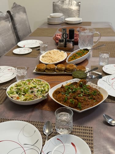 Customer's delicious meal prepared from the Halal Whole Chicken, served as a curry on a full dining table.