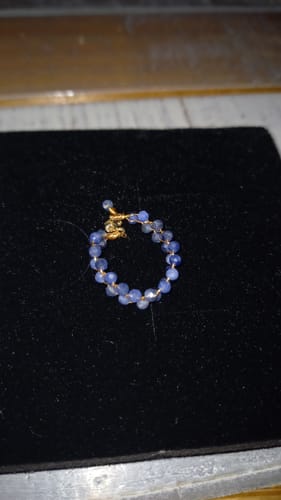 Avis du client : La bague en cyanite est posée sur une surface noire unie.