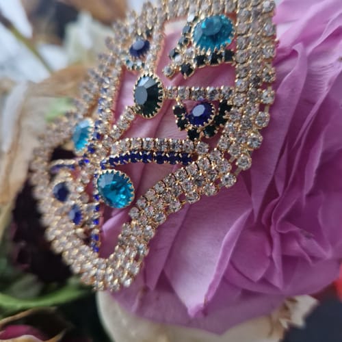 Customer's close-up of an ornate, jeweled accessory on a purple rose.