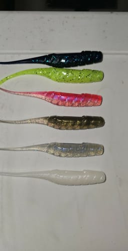Reviewer's six Texas Custom Lures soft plastic lures in various colors laid out on a white surface.