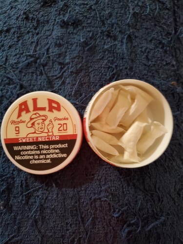 Customer's open tin of Sweet Nectar Nicotine Pouches with the lid beside it, showing the pouches inside.