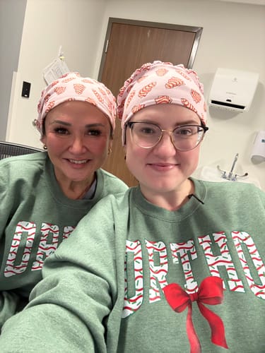 Two reviewers wearing matching festive DuoStyle Scrub Hats with the Christmas Tree Cakes pattern in a medical office.