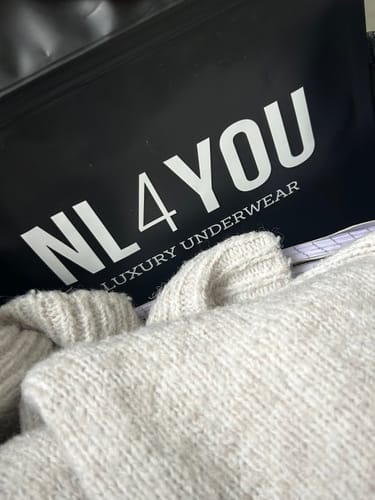 Customer's close-up of the soft white Tulled underwear next to its branded NL4YOU packaging.