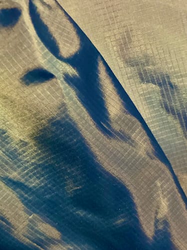 Reviewer's close-up of the shiny blue Ripstop Fabric, highlighting the grid texture.