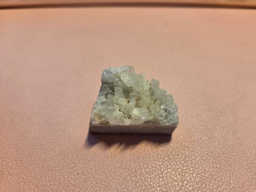 Customer's small quartz cluster from their VIP Crystal Club subscription, resting on a pink surface.
