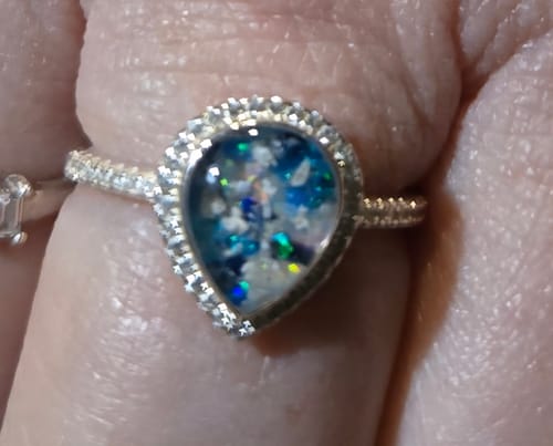 Close-up of a reviewer wearing their Bedazzled Pear Opal Ring with Cremation Ashes on their finger.