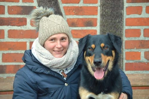 Eine Rezensentin sitzt mit ihrem Hund, dessen glänzendes Fell das Ergebnis der Einnahme von Lachsöl ist.