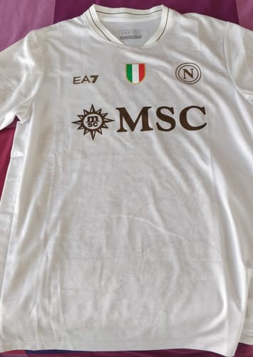 Recensore mostra la sua MAGLIA NAPOLI AWAY bianca, con loghi dorati e lo scudetto.