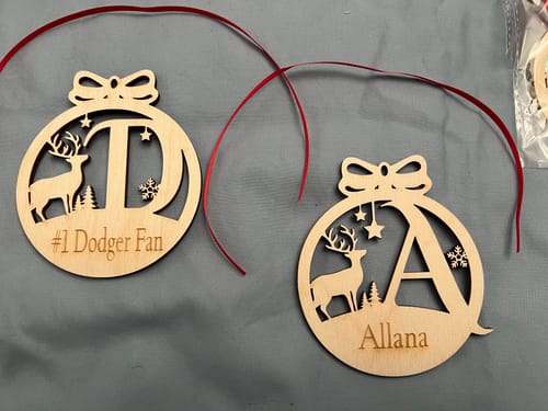 Customer's two personalized monogram deer ornaments, one with a 'T' and '#1 Dodger Fan,' the other with an 'A' and 'Allana'.