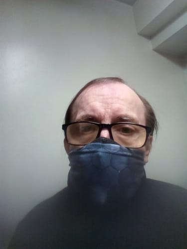 Customer wearing the Starship TPS Gaiter pulled up over their nose, with the fabric bunched around their neck.