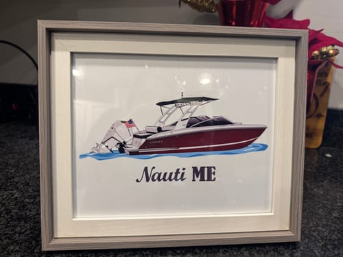 Customer's framed Custom Digital Boat Artwork of a red motorboat with the text 'Nauti ME' underneath.