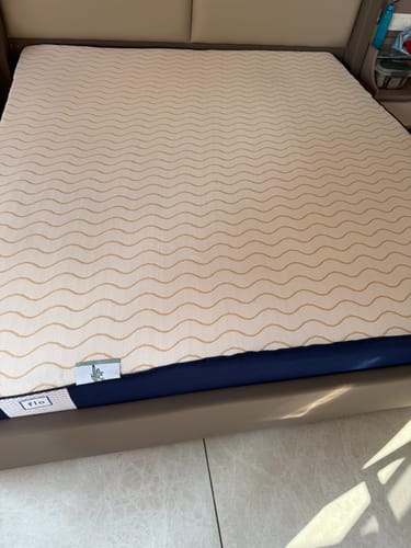 Customer's Flo Mattress Ergo on a bed, showing the patterned top cover and solid blue side.