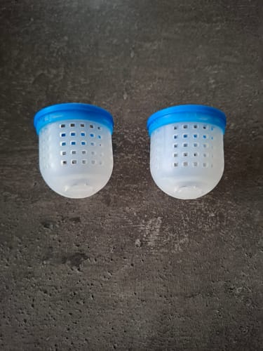 Recensent toont twee geperforeerde Soft Cad Pots met blauwe randen op een donkergrijze ondergrond.