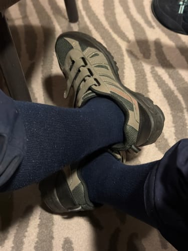 Customer wearing the dark Performance Eucalyptus Compression Socks with walking shoes indoors.