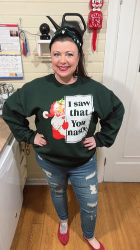 Reviewer wearing the green 'I Saw That You Nasty' sweatshirt, posing to show the size XL fit in a kitchen.