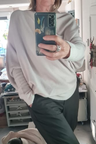 Reviewer taking a mirror selfie wearing the light beige Asymmetric Draped seamless knit top.