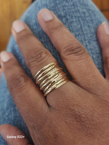 Customer wearing the gold plated Chunky Wrap Wide Band Ring on their finger against blue denim.