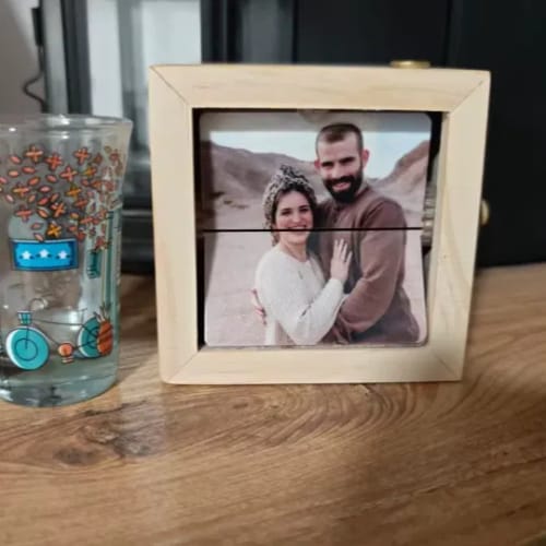 Customer's light-wood Personalized Photo Box on a wooden table, displaying a photo of a smiling couple.