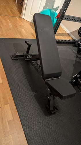 Customer's black Heavy Duty Utility Bench assembled and set to an incline position on a gym mat.