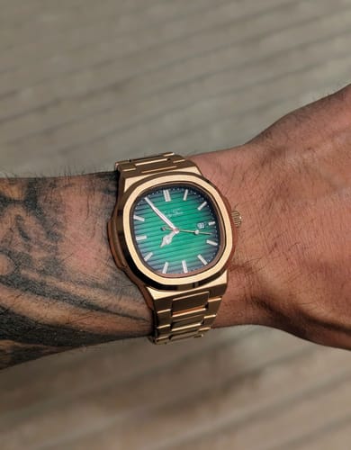 Customer's Lucky Fours® Wraith watch with a green dial and gold-colored case, shown on a tattooed wrist.