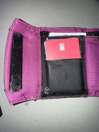 Reviewer's red SPOTMINDERS Tracking Card PRO shown inside a card slot of an open purple wallet.