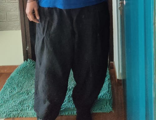 A reviewer showing the comfortable, loose fit of the black Boxate Yoga Pants.