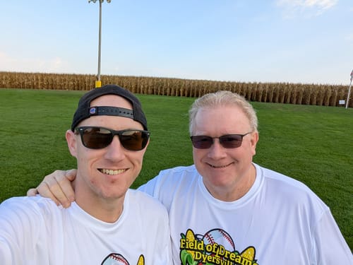 Reviewer and a companion at a baseball field, the setting where they enjoy BACKYARD BBQ seeds.