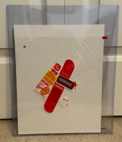 Reviewer's 11 x 14 Photo Top Loader protecting a vintage paper collectible against a white door.