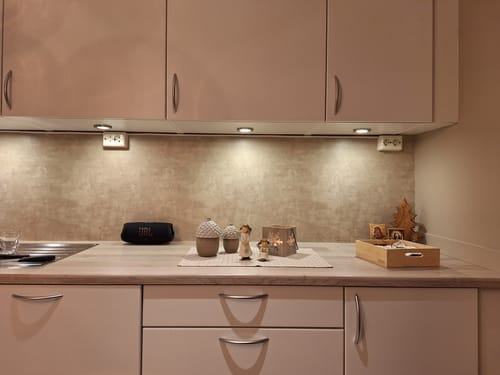 Nærbilde av Premium Limewash beige kontaktplast brukt som backsplash på et kjøkken, som viser teksturen.
