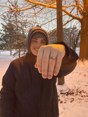 Customer happily showing their hammered titanium Terra ring on their hand in the snow.