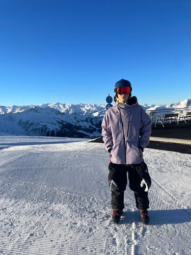 Reviewer wearing the light purple Snow Jacket on a snowy mountain.